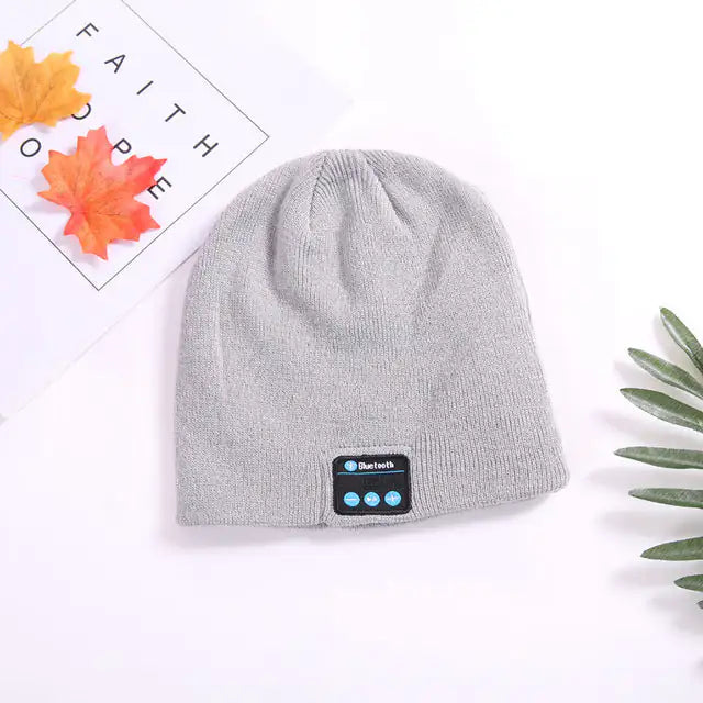 a gray beanie hat with a blue button on it