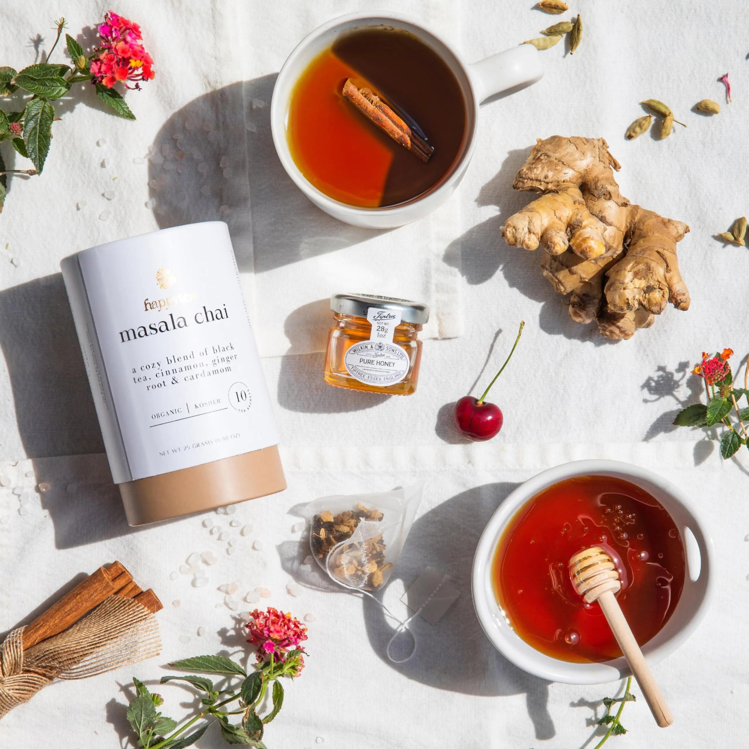 a cup of tea next to a jar of honey and a cup of tea