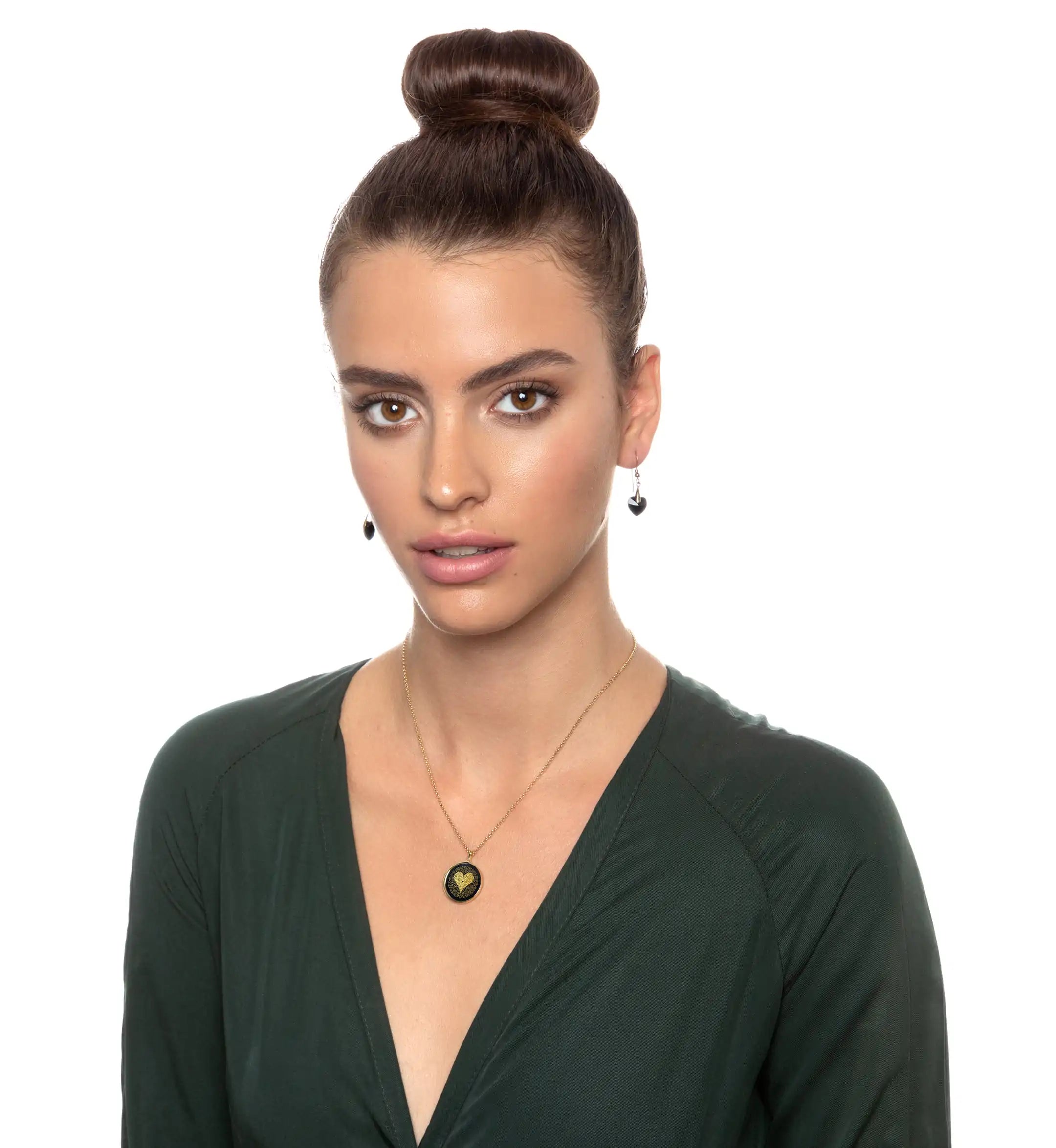 a woman wearing a green top with a bun in her hair