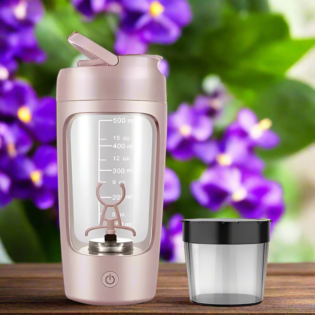 a pink blender next to a purple flower