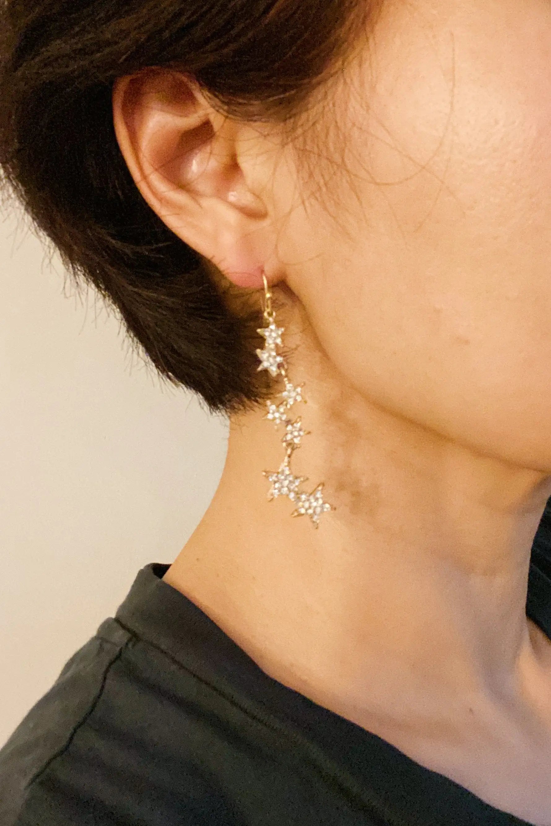 a close up of a person wearing a pair of earrings
