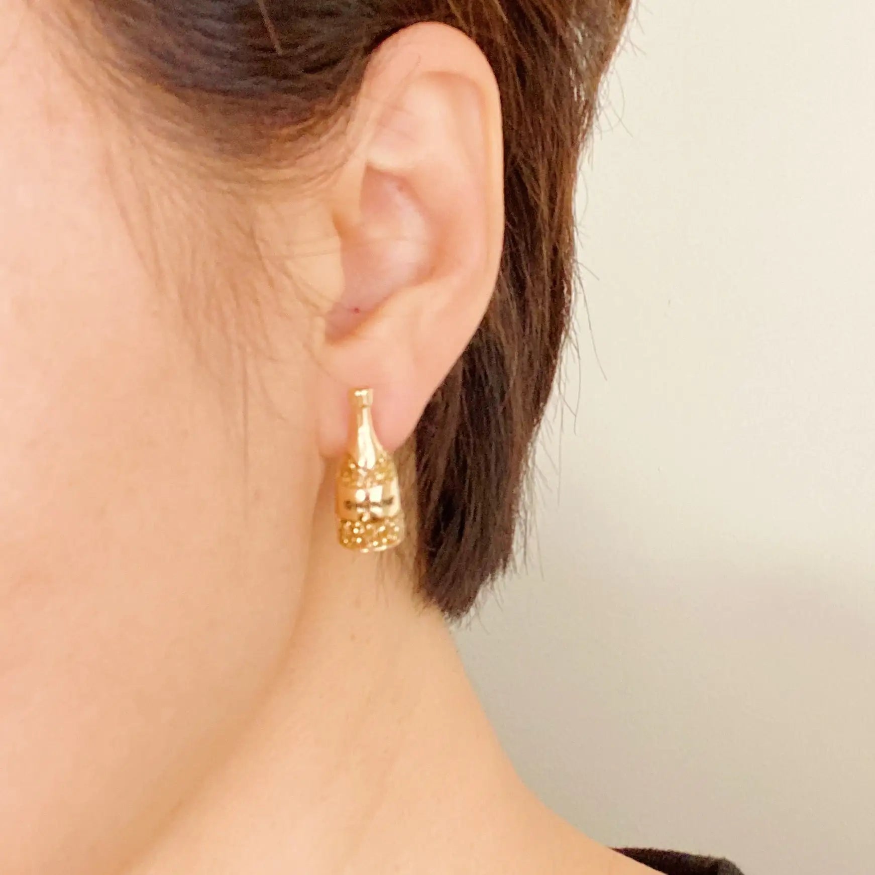 a close up of a person wearing a pair of earrings