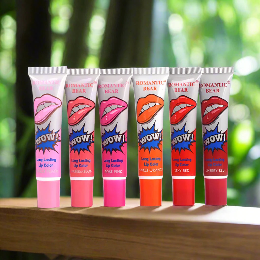 a row of lip glosses sitting on top of a wooden table