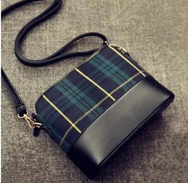 a black and blue plaid purse sitting on top of a floor