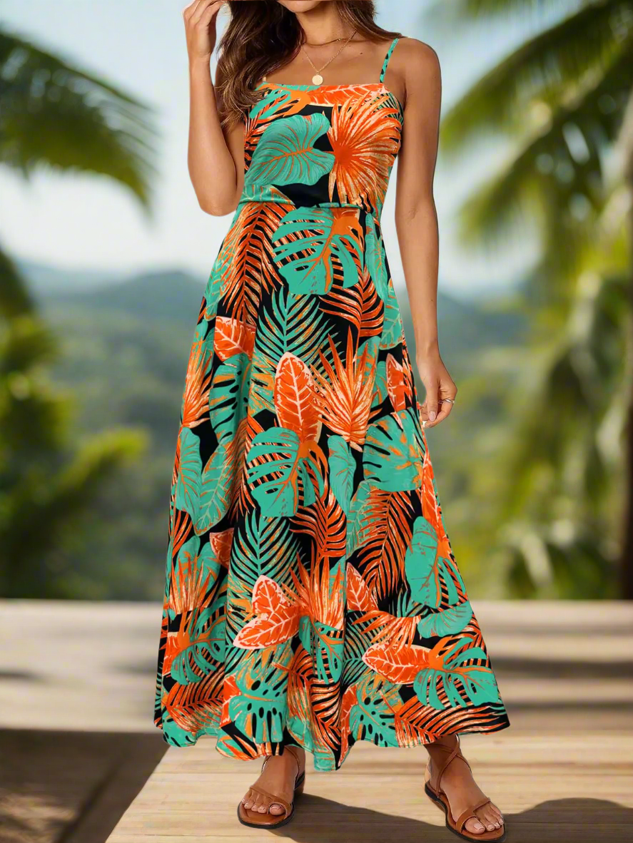 The MEROKEETY 2024 Summer Floral Boho Maxi Dress, displayed against a scenic backdrop. This floral boho maxi dress has a striking design with vivid greens and oranges in a tropical print. Ideal for warm weather, it features spaghetti straps and full-length styling. This piece from Blooming Violets is a must-have for women's fashion this spring and summer, complete with free shipping.