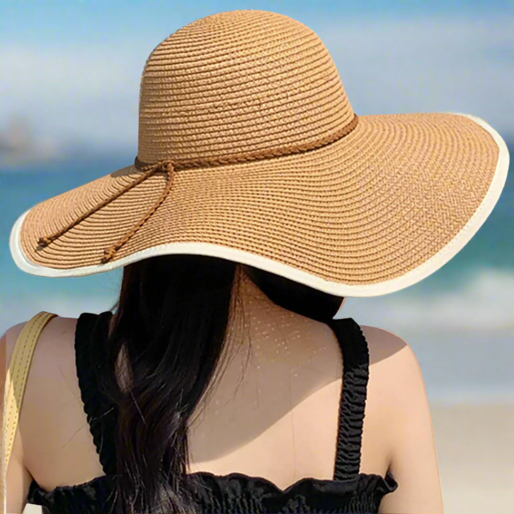 A woman showcases the DRESHOW Womens Bowknor Straw Hat, featuring a fashionable wide brim. This stylish foldable sun hat is perfect for summer fun, offering UPF 50+ protection. Produced by Blooming Violets, it combines functionality with fashion for ladies who love spending time outdoors. This convenient roll-up straw hat is an essential womens sun hat for spring, with free shipping available.