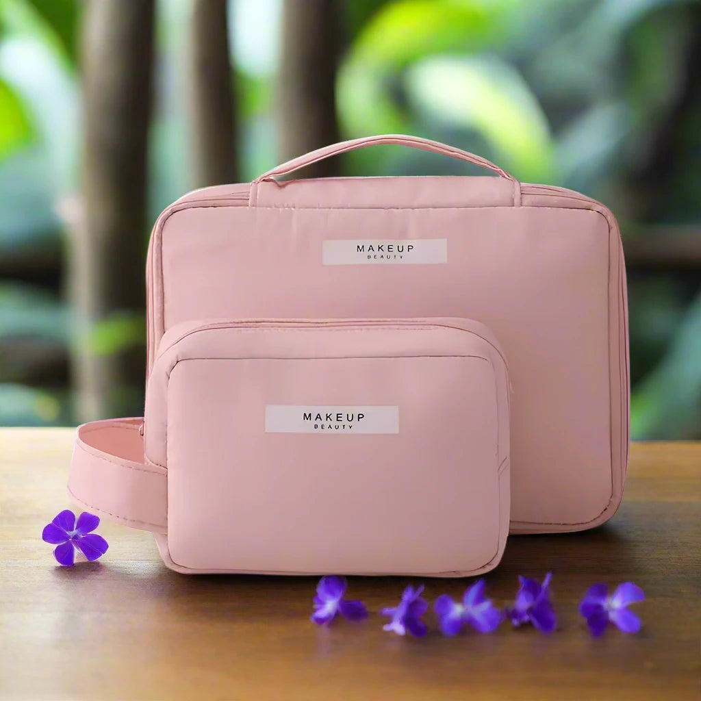 two pink makeup bags sitting on top of a wooden table