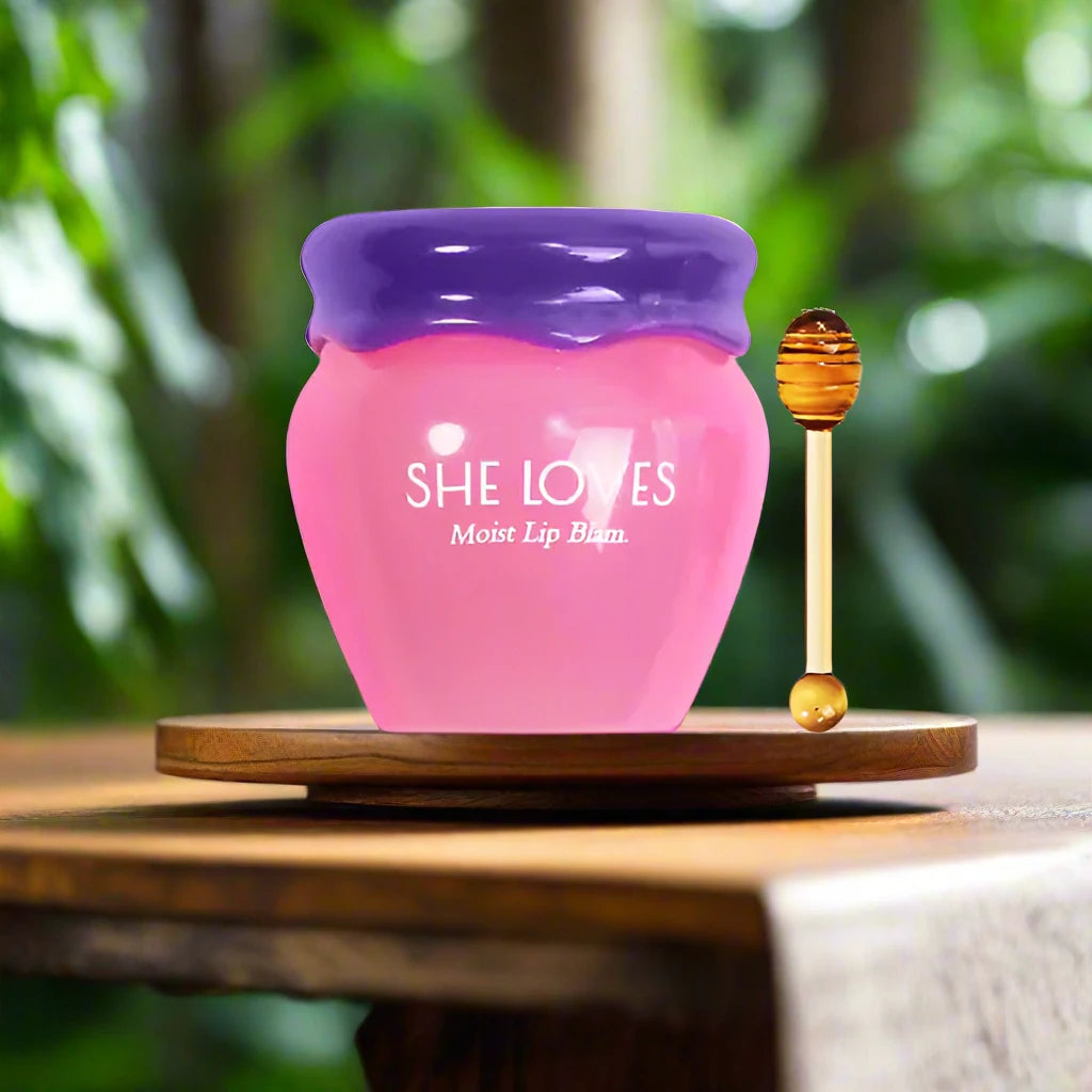 a pink jar with a purple lid sitting on a wooden table