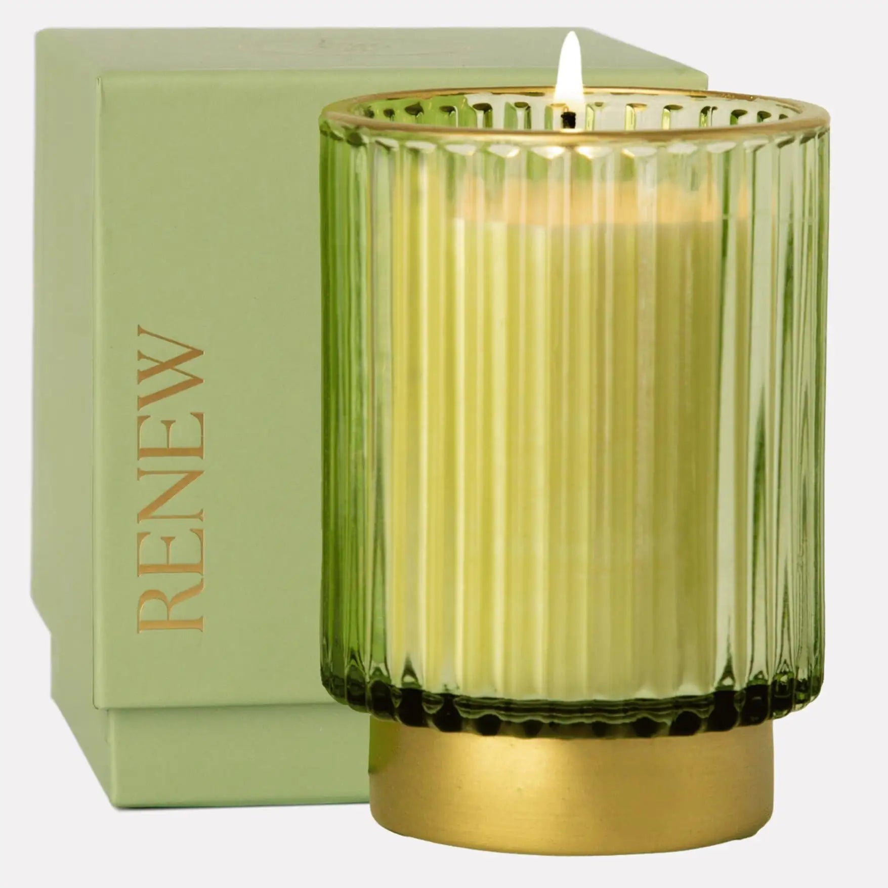 a green glass candle sitting next to a box