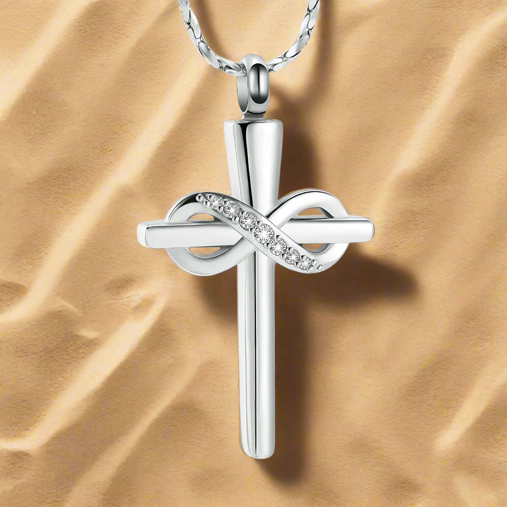 Imrsanl Infinity Love Cross Cremation Jewelry Ashes Religious Cross Urn Pendant Necklace for Women Men Pet Ashes Memorial Keepsake Jewelry, captured against a sandy background. This silver cross pendant is a heartfelt symbol of love and loss, designed for those who need a cherished reminder of their dearly departed, merging inspiration, faith, and beauty in a single piece.