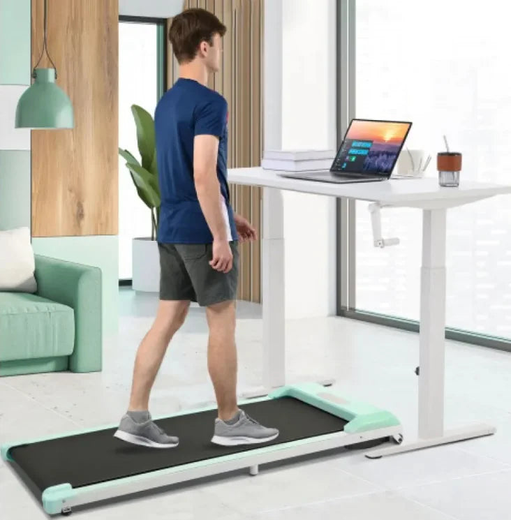 a man walking on a treadmill using a laptop